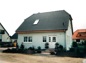 Einfamilienhaus Barby mit weißer Fassade und Dachfenster